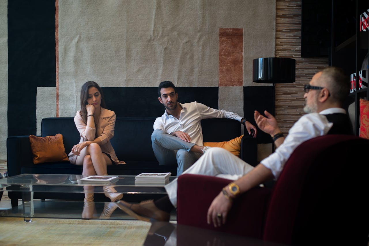 gallery-04 Three adults engaged in a thoughtful therapy session in a stylish Genoa interior.