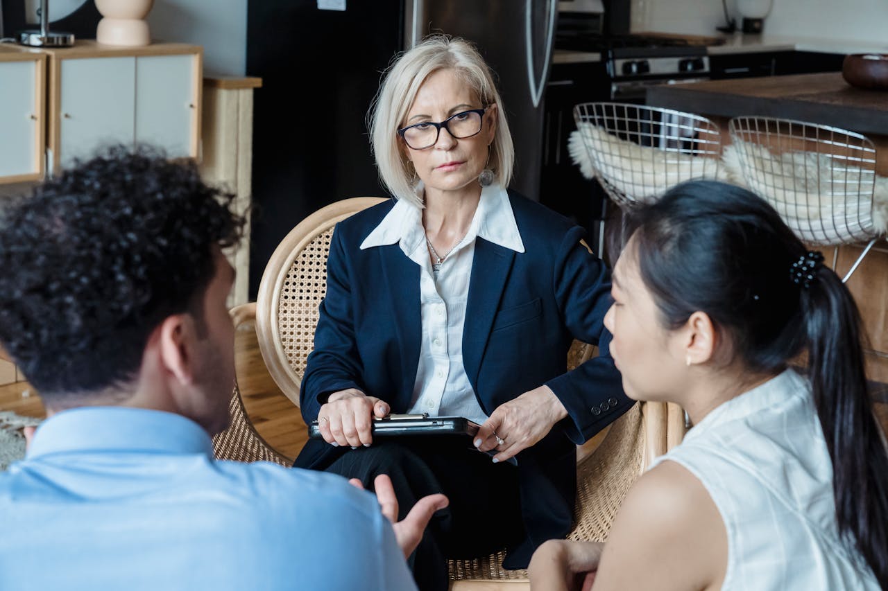 gallery-05 A professional therapist engages with a couple during a counseling session indoors.